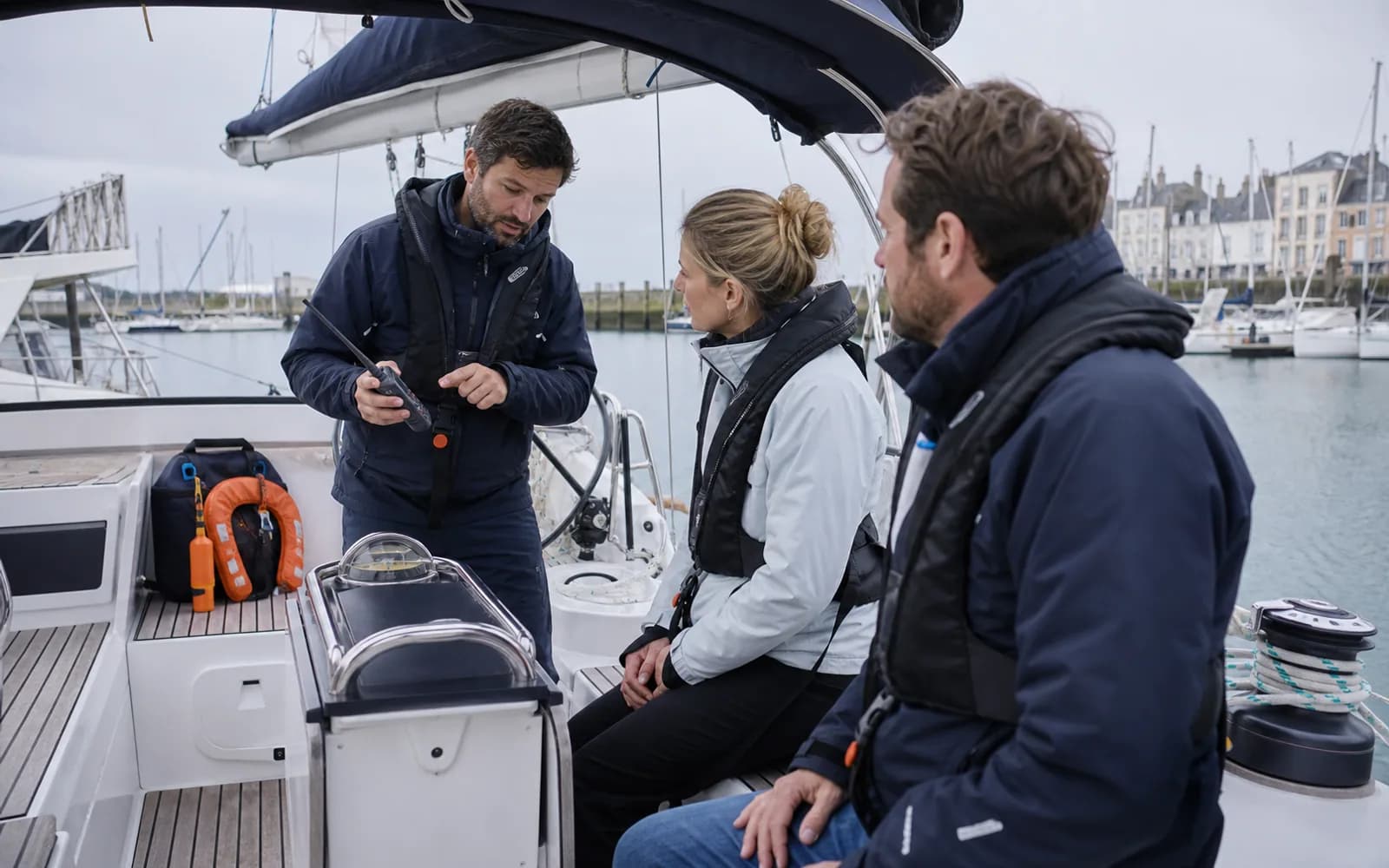 Chef de bord présentant la VHF et les équipements de sécurité à son équipage