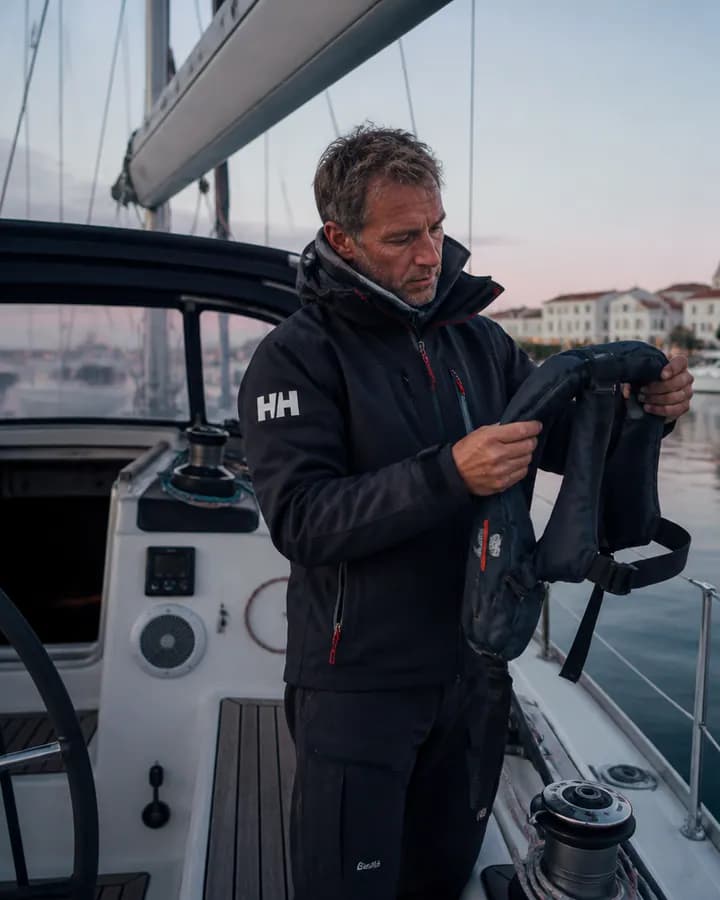 Plaisancier vérifiant un gilet de sauvetage à bord de son voilier